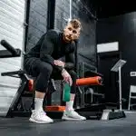 woman in black long sleeve shirt and black pants sitting on exercise equipment