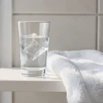 Verre d'eau froide et linge propre pour soigner une plaie dans la bouche